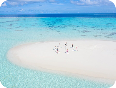 People doing Yoga next to the beach on a small island
